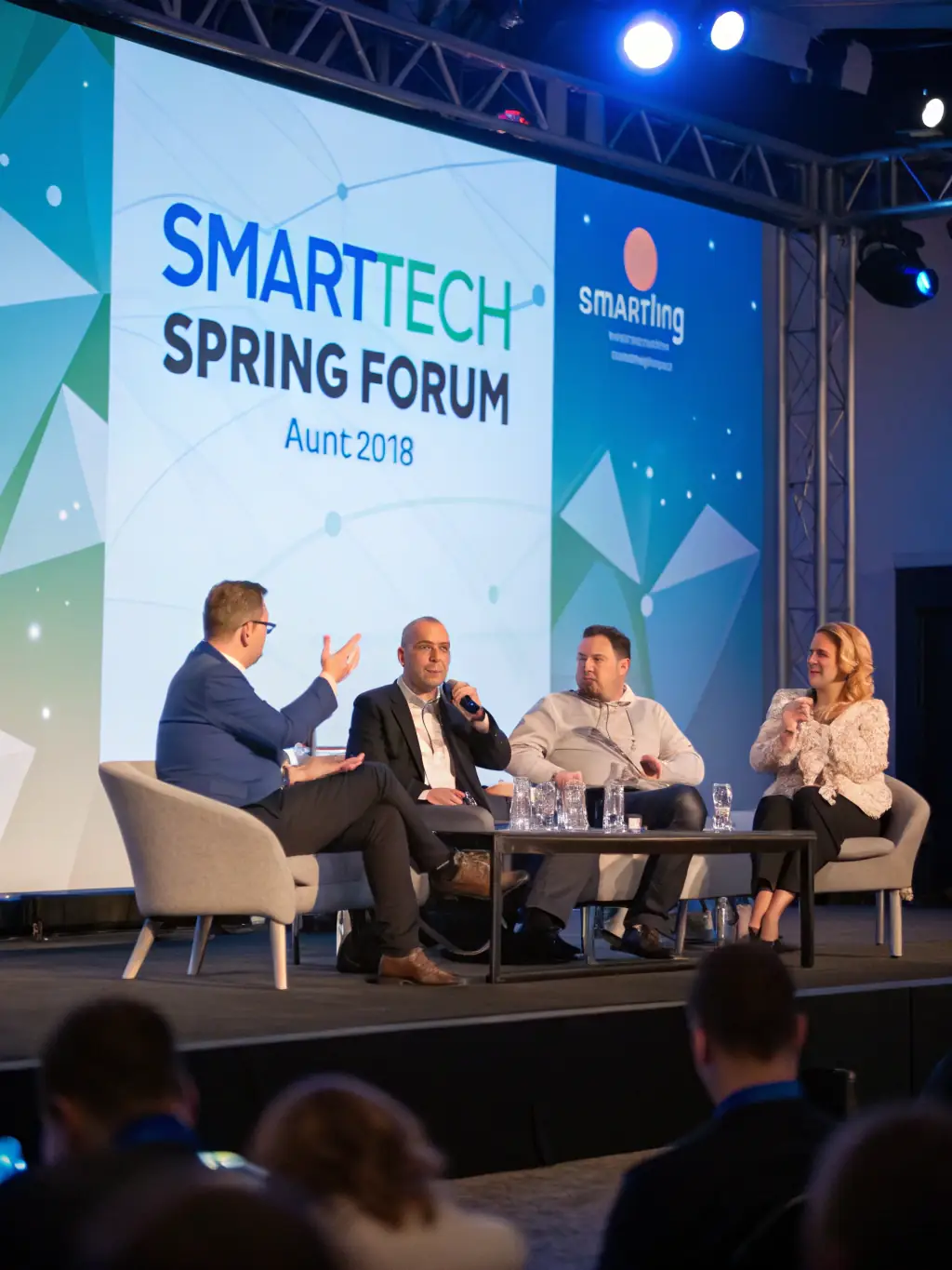 A photograph of a conference hall during a panel discussion at TechConclaveUK, with attendees actively participating and engaging with the speakers.